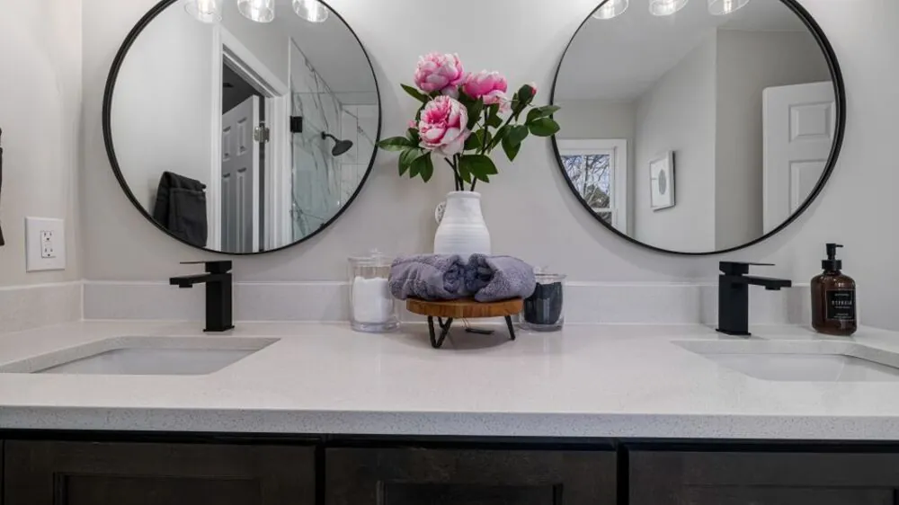 Bathroom vanity with a mirror task light brushed metal tap and stone counter