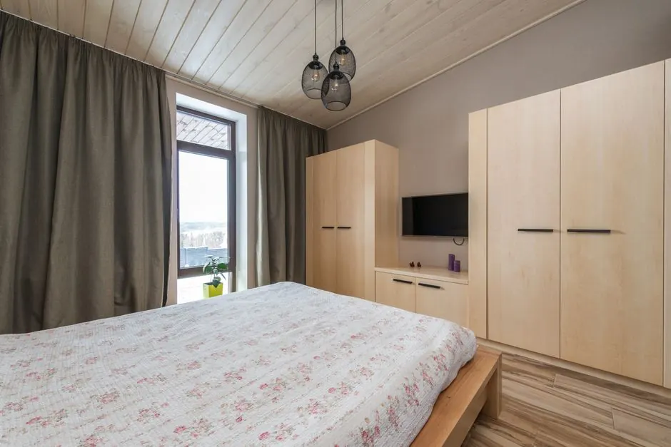 Modern bedroom with a wooden wardrobe wall and a platform bed