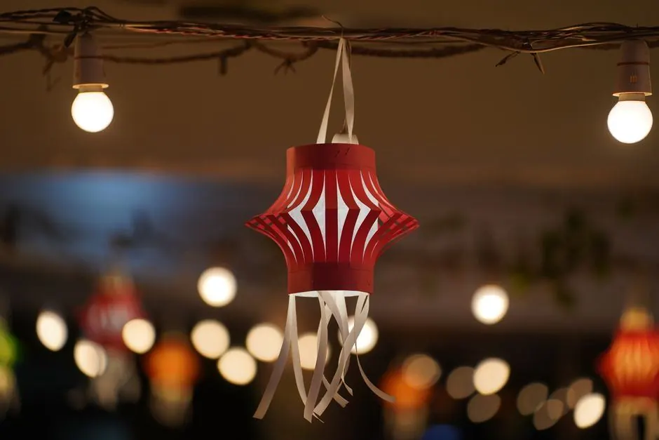 Paper lantern hanging among warm string lights as Diwali decoration