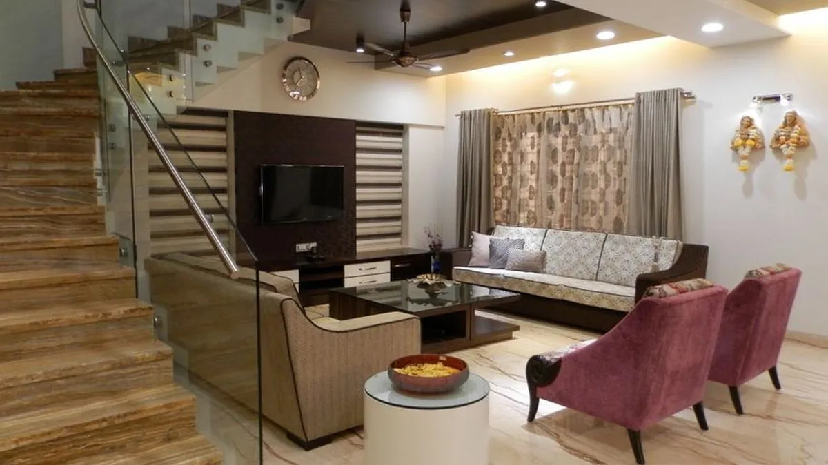 Chennai living room with a layered false ceiling and warm perimeter lighting