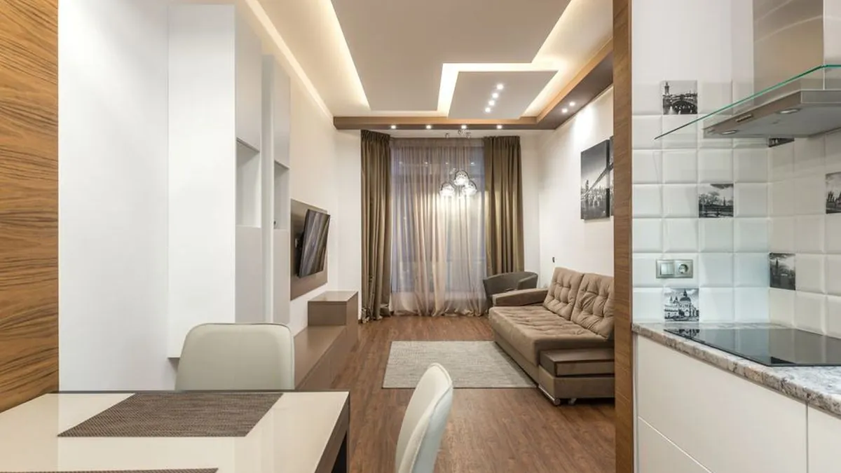 Living room with a stepped gypsum false ceiling and concealed cove lighting
