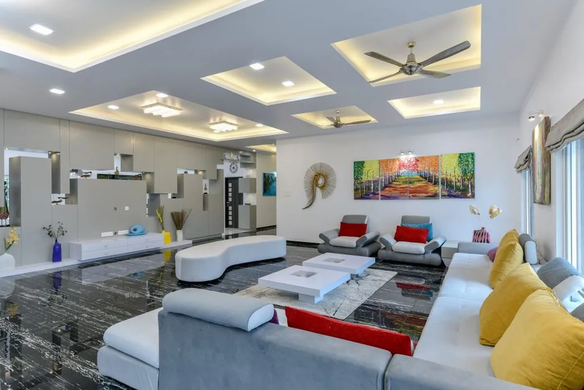 Black veined marble flooring in a spacious living room with a recessed ceiling
