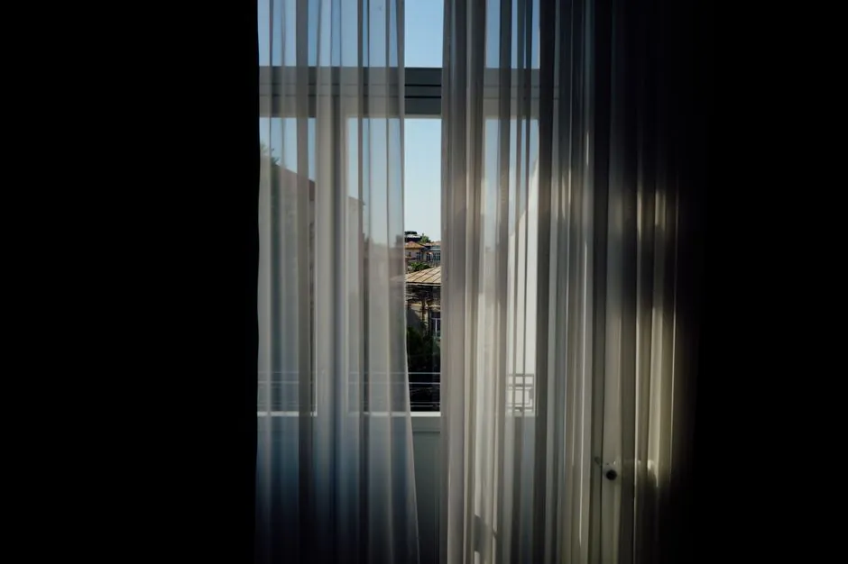 Light curtains framing a window in an apartment room