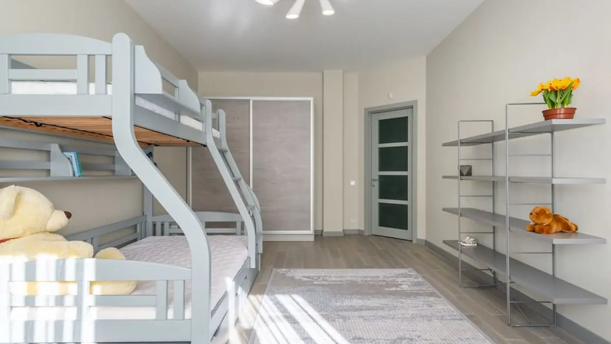 Children bedroom with a grey bunk bed, sliding wardrobe and open shelves