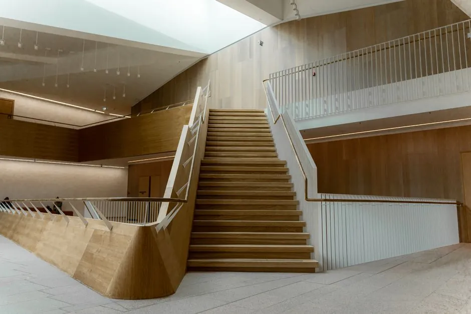 Marble stair treads with dark anti-slip inlay beside a timber panelled wall