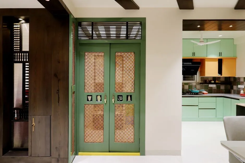 Entrance hallway of an Indian home with a wooden main door and natural light