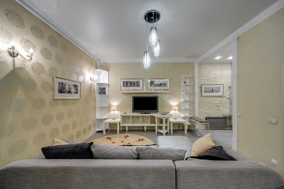 Living room with a patterned cream feature wall beside plain cream walls and a white ceiling